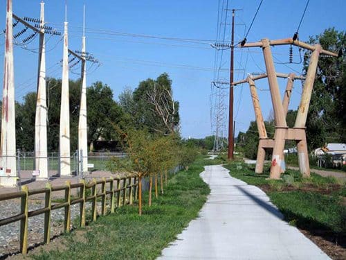 Transmission towers next to bikeway and metal fences Transmission towers next to bikeway and metal fences